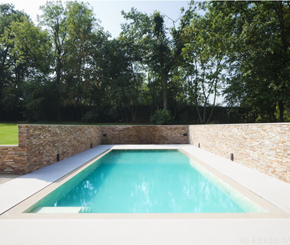 Betonnen zwembad bekleed met natuursteen tegels, Hugelier zwembadbouwer West-Vlaanderen