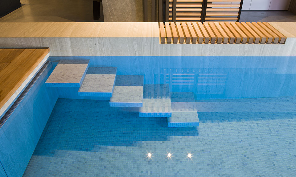 Design binnenzwembad beton glazen wand, hoogwaardige afwerkingsmaterialen en zwevende trap ‹ De Mooiste