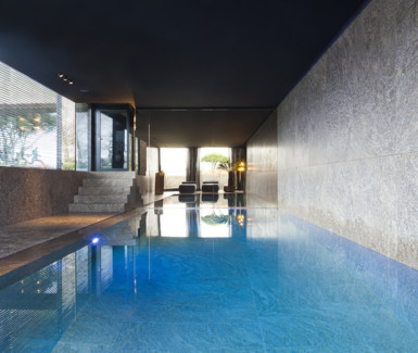 luxe zwembad bekleed met natuursteen, aangelegd door West-Pool zwembadbouwer uit Ingelmunster
