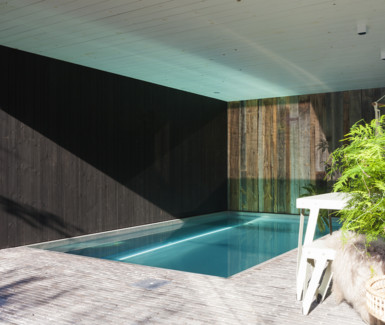inox binnenzwembad aangelegd in poolhouse uit barnwood door Nouv'eau