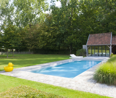 luxueus buitenzwembad bekleed met keramische tegels en glasmozaiek aangelegd door DcPools, demooistezwembaden.be